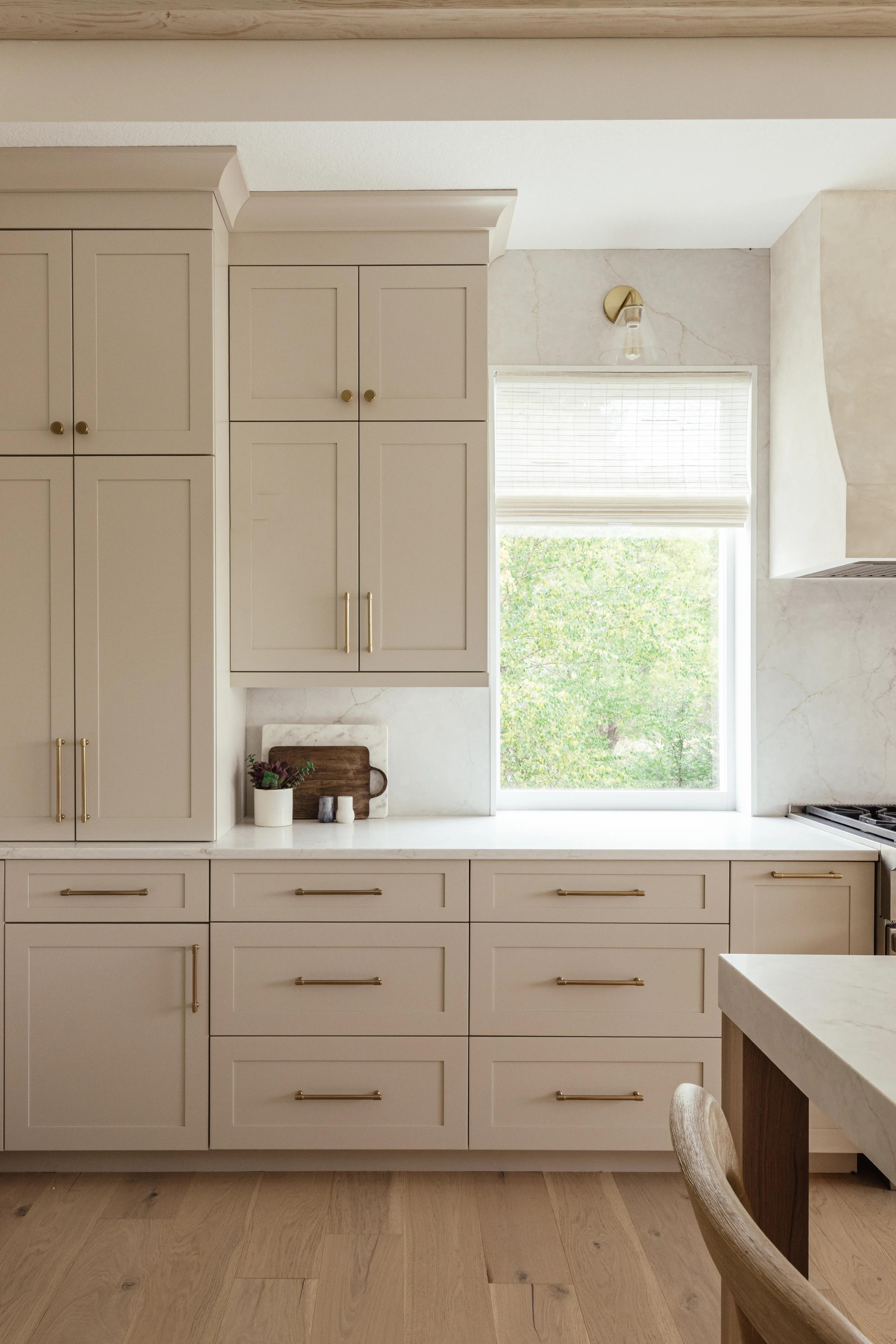 Close-up of Plateau drawer fronts and doors in Accessible Beige with gold hardware