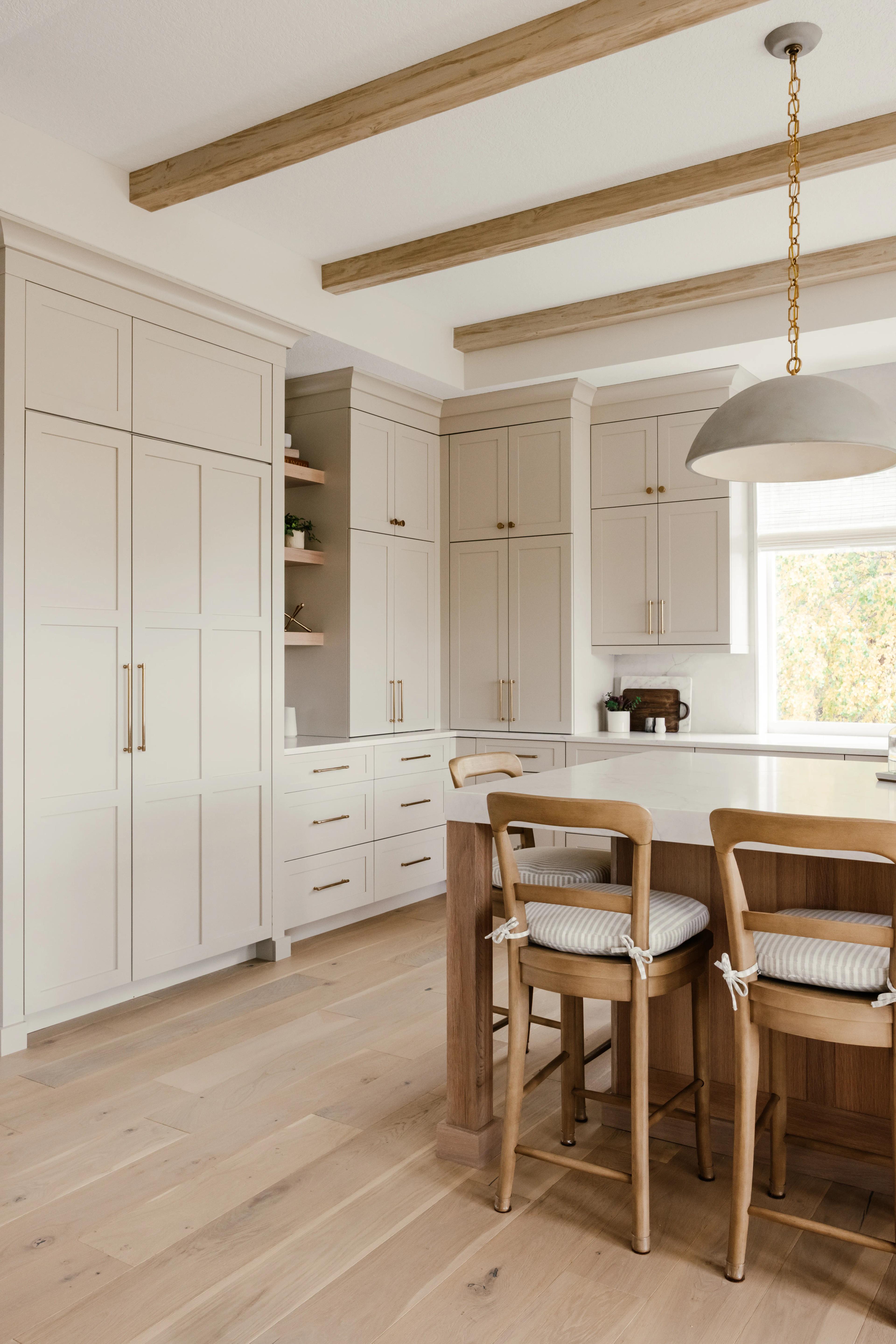 Tall Accessible Beige Plateau pantry cabinets and open shelves beside a White Oak island by Revival House Design